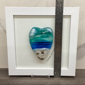 A conical shaped sea scene heart in a white frame, with a ruler to demonstrate the height of the piece.