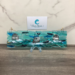 Fused Glass Large Trio of Seals Hanger main product image. Displayed on a stand with a business card.