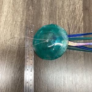 Fused Glass light aqua jellyfish with a ruler for scale and measurement of the width.
