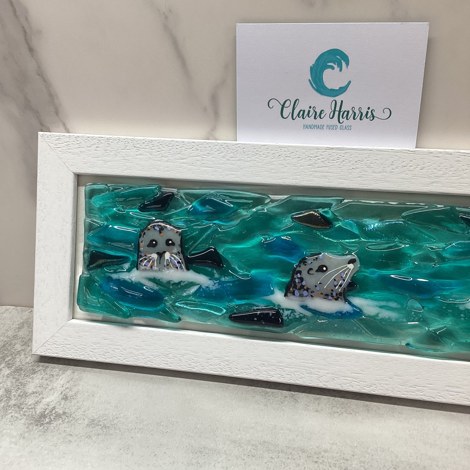 Regular sized framed Trio of Seals main product photo, with a business card.