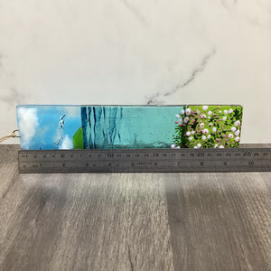 Fused glass large hanger with sea pinks, with a ruler depicting the length of the piece. 